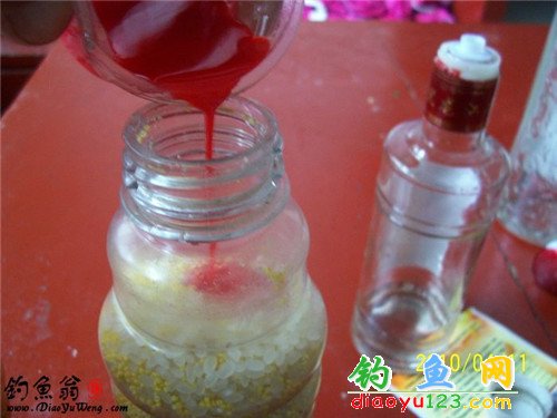 Shaking a glass jar to mix rice, millet, and the wine-additive mixture for fishing chum